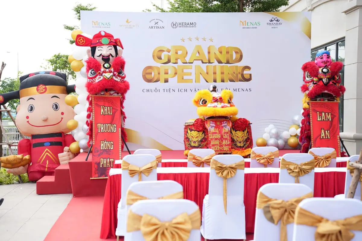 Sân khấu lễ khai trương với backdrop Grand Opening, đôi lân và Thần Tài
